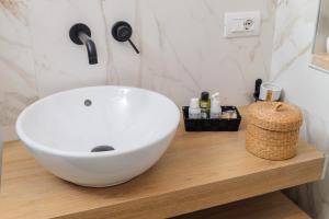 un bagno con un lavandino bianco su un bancone in legno di Portico dei Sogni Prima Fila Mare a San Benedetto del Tronto