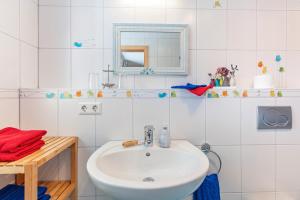 a white bathroom with a sink and a mirror at Ferienwohnung Bergahorn in Todtnauberg +70 photos