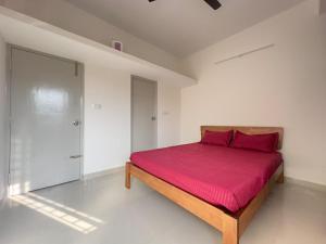 a bedroom with a bed with a red bedspread at 1Bhk in Hennur 1st floor near Bhartiya city 101 in Bengaluru