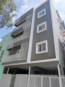 a gray building with white windows and a fence at 1Bhk in Hennur 1st floor near Bhartiya city 101 in Bengaluru