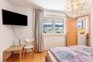 a bedroom with a bed and a desk and a tv at Ferienwohnung Bergahorn in Todtnauberg