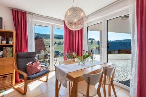 a dining room with a table and a large window at Ferienwohnung Bergahorn in Todtnauberg
