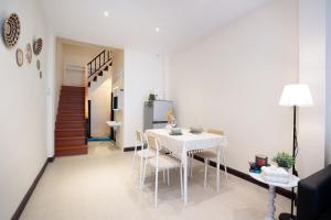 une salle à manger avec une table et des chaises blanches dans l'établissement OH Homes - Samsen 10, à Bangkok