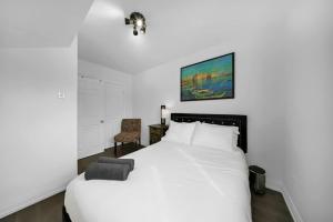 トロントにあるHidden 3BR Gem with Workspace, Fast wifi and Parkingの白いベッドと椅子のある寝室
