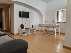 a living room with a table and chairs and a tv at Casa das Amas do Cardeal in Évora +6 photos