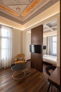 een kamer met een gewelfd plafond en een tafel en een bed bij Bouquet Luxury Rooms in Chania