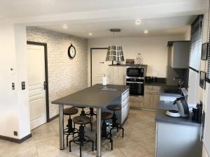 - une cuisine avec une table et quelques tabourets dans l'établissement La Brocante, à Granges-Aumontzey