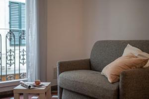 een woonkamer met een bank, een tafel en een raam bij The Florentine Backpacker in Florence +21 foto's