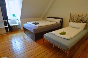 曼海姆Quadrate Hostel Mannheim Z6 Denkmalschutz的有两张床和一把椅子的房间