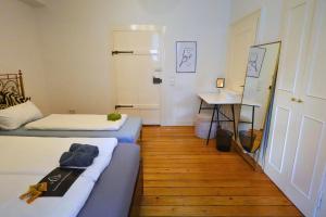 曼海姆Quadrate Hostel Mannheim Z6 Denkmalschutz的有两张床和一张桌子的小房间