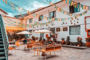 a patio of a restaurant with tables and chairs and flags at Viajero Cusco Hostel in Cusco