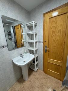 W łazience znajduje się umywalka, lustro i półka. w obiekcie Apartment Goya w mieście Torrevieja +37 zdjęć