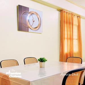 a table with chairs and a picture on the wall at Acacia Family Nook by The Pineview Chateau in Baguio