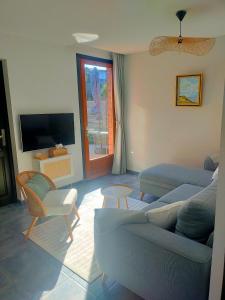 a living room with a couch and a tv at Maison avec terrasses à 300m de la mer Juno Beach in Bernières-sur-Mer