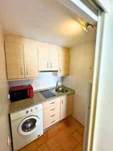 una pequeña cocina con lavadora y fregadero en Home4u Castillejos, en Granada