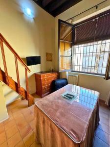 Una habitación con una mesa y un escritorio y una escalera. en Home4u Castillejos, en Granada