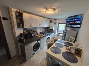 een keuken met een wastafel en een tafel. bij OLE Apartment - CENTRAL - Parking included in Timişoara