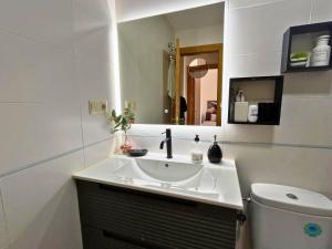 a white bathroom with a sink and a toilet at Home4u Calle Barcelona in Armilla +23 photos