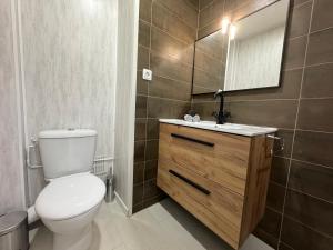 a bathroom with a toilet and a sink and a mirror at Appartement 300m de la mer in Valras-Plage