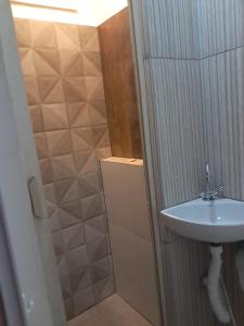 a bathroom with a sink and a shower at Apartamento estudio in Muriaé +15 photos