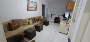 salon z kanapą i telewizorem z płaskim ekranem w obiekcie Casa cinza em frente à praia em condominio w mieście Aracaju +13 zdjęć