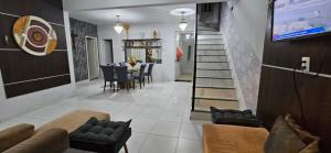 salon z kanapą i stołem z krzesłami w obiekcie Casa cinza em frente à praia em condominio w mieście Aracaju