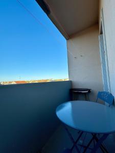 a blue table in a room with a window at Appartement 300m de la mer in Valras-Plage