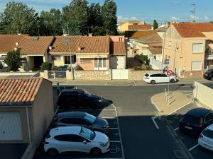 a group of cars parked in a parking lot at Appartement 300m de la mer in Valras-Plage
