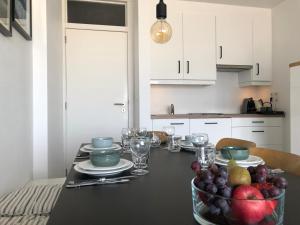a dining room table with a bowl of fruit on it at Oostduinkerke Estacade ZEEDIJK in Oostduinkerke