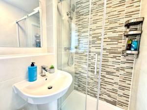 a white bathroom with a sink and a shower at Walnut Flats-F5, Stylish 1-Bedroom - Parking, Netflix, WIFI - Close to Oxford, Bicester & Blenheim Palace in Kidlington +35 photos