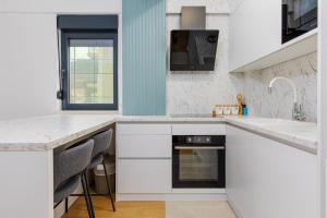 Una cocina con gabinetes blancos y encimera. en Budva Center Premium Suite, en Budva 20 fotos más