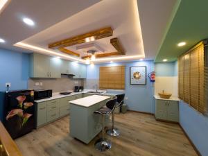 a kitchen with blue and green walls and a counter at Satori Apartment in Kathmandu
