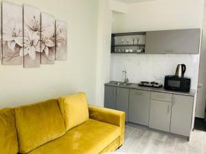 a living room with a yellow couch and a kitchen at Family Guest House in Yerevan +15 photos