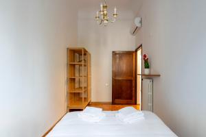 a bedroom with a bed with white sheets and a chandelier at Eventi e Relax vicino all'Artemio Franchi e al Centro Storico in Florence +49 photos