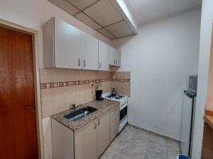 a small kitchen with a sink and a stove at Dto funcional MT in Bahía Blanca