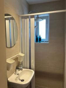 メンヒェングラートバッハにあるStilvolles Studio Apartment im Zentrum MGの洗面台と鏡のある白いバスルーム