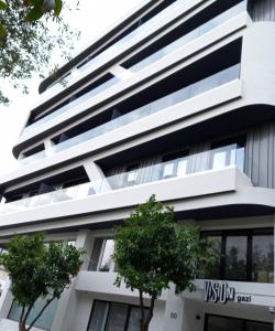 a white building with trees in front of it at Vision Gazi in Athens