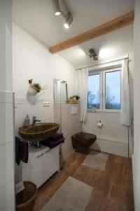 a bathroom with a wooden sink and a wooden floor at Hinterhaus in Herdwangen