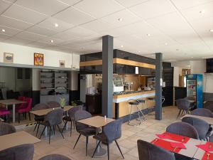 a restaurant with tables and chairs and a counter at Hôtel De La Gare Périgueux in Périgueux