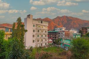 un gruppo di edifici con montagne sullo sfondo di Divine Dev Darshan Valley a Rishikesh