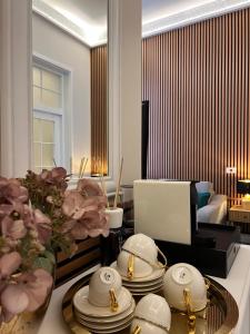 een woonkamer met een tafel met borden en bloemen bij Apartment Deluxe Bucharest Downtown in Boekarest