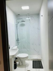 a white bathroom with a toilet and a sink at Family Guest House in Yerevan