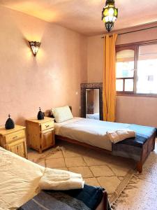 a bedroom with two beds and a window at Town Gate in Tamraght Ouzdar