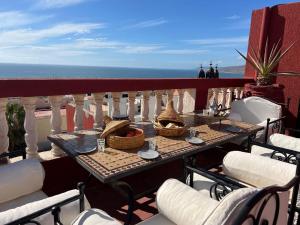 a table on a balcony with a view of the ocean at Town Gate in Tamraght Ouzdar +29 photos
