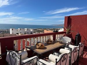 a table and chairs on a balcony with a view at Town Gate in Tamraght Ouzdar
