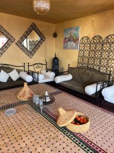 a room with two beds and a table with a bowl of fruit at Town Gate in Tamraght Ouzdar