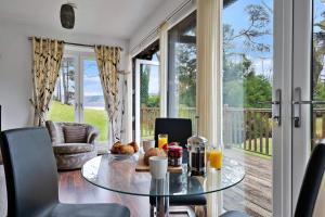 a dining room with a glass table and a balcony at Finest Retreats - The Turbine House in Achahoish