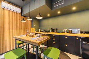a kitchen with a wooden table and green chairs at Arena Albaro House in Genoa