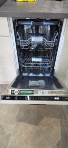 an open dishwasher with its door open on a floor at Heïdi 7 in Middelkerke