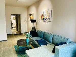 a living room with a blue couch and a table at Family Guest House in Yerevan